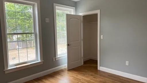 an empty room with wooden floor and a window