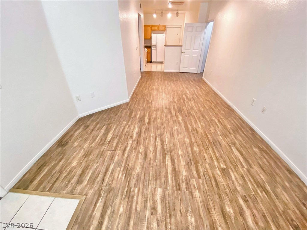 10550 West Alexander Road, Unit 1131 Las Vegas, NV 89129 - Photo 4 of 18 Natural wood-look flooring extends through this versatile open-concept living area, leading to the kitchen.