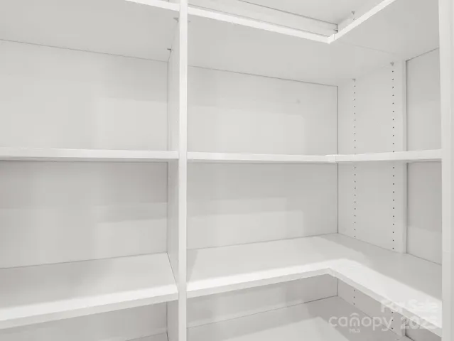 a view of a big room with windows and chandelier fan