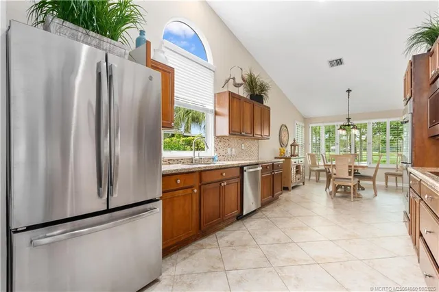 a kitchen with stainless steel appliances granite countertop a refrigerator and a stove top oven