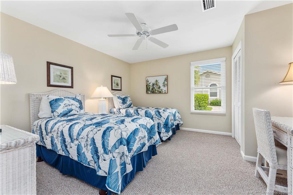 12813 Northwest Cinnamon Way Palm City, FL 34990 - Photo 18 of 33 a bedroom with two beds and painting on the wall