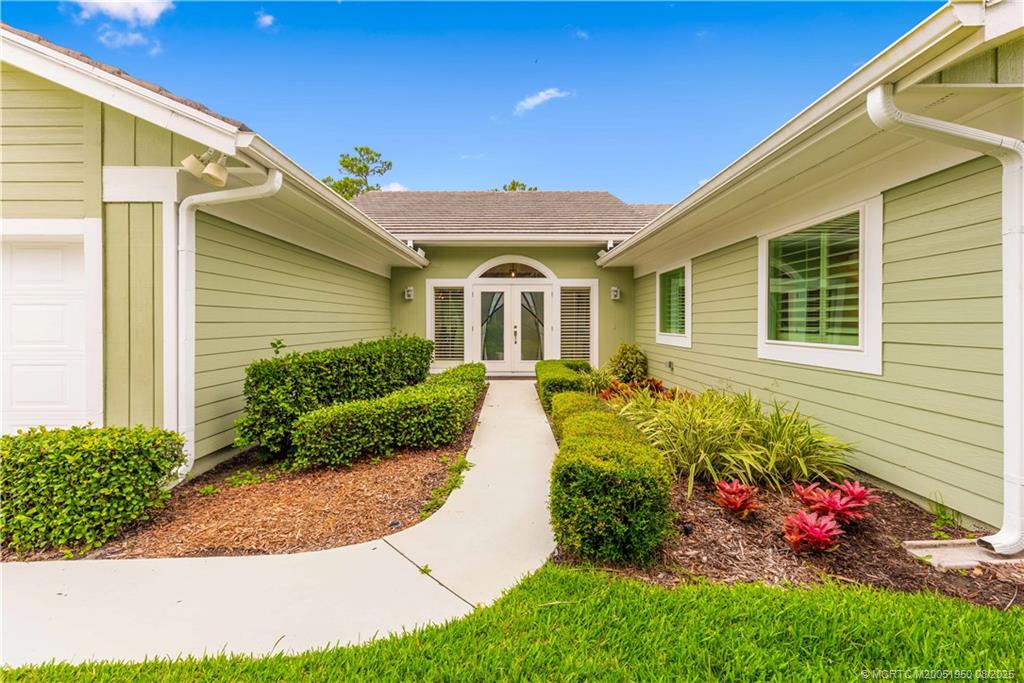 12813 Northwest Cinnamon Way Palm City, FL 34990 - Photo 4 of 33 a front view of a house with a yard