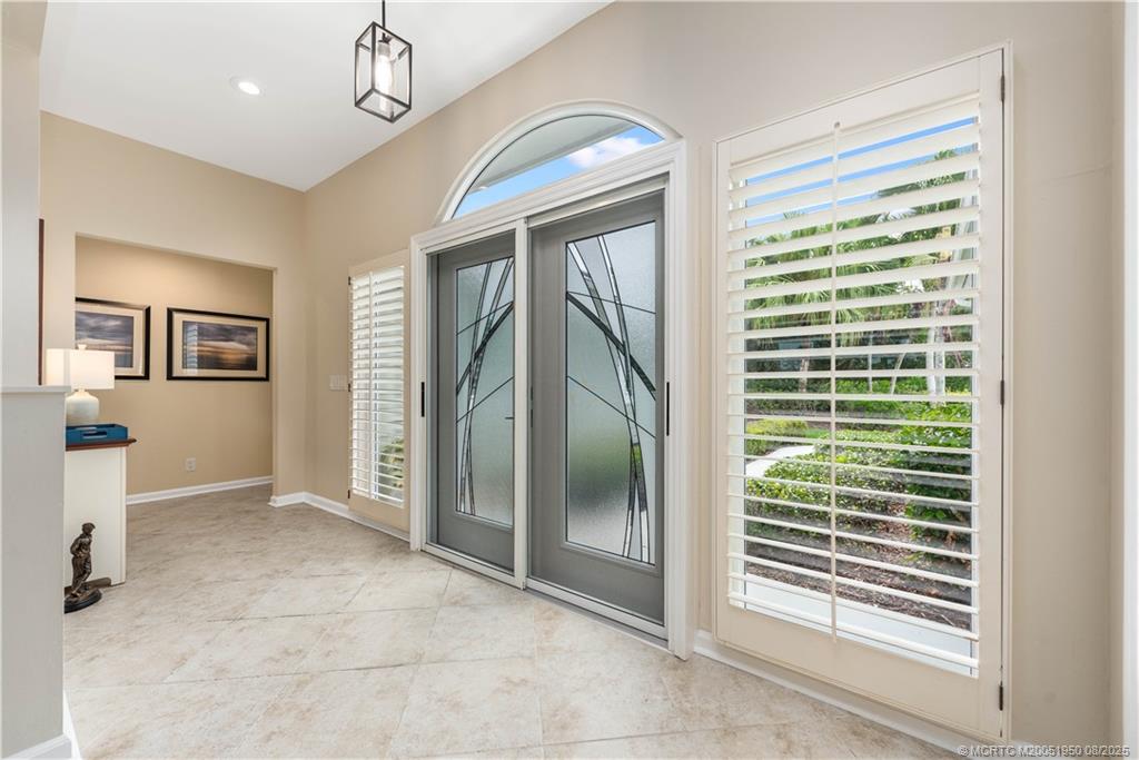 12813 Northwest Cinnamon Way Palm City, FL 34990 - Photo 5 of 33 a view of empty room with windows and chandelier