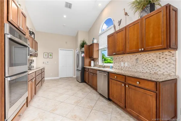 a kitchen with stainless steel appliances granite countertop a refrigerator sink and cabinets