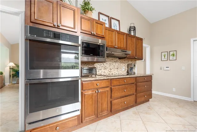 a kitchen with granite countertop cabinets stainless steel appliances and a counter space
