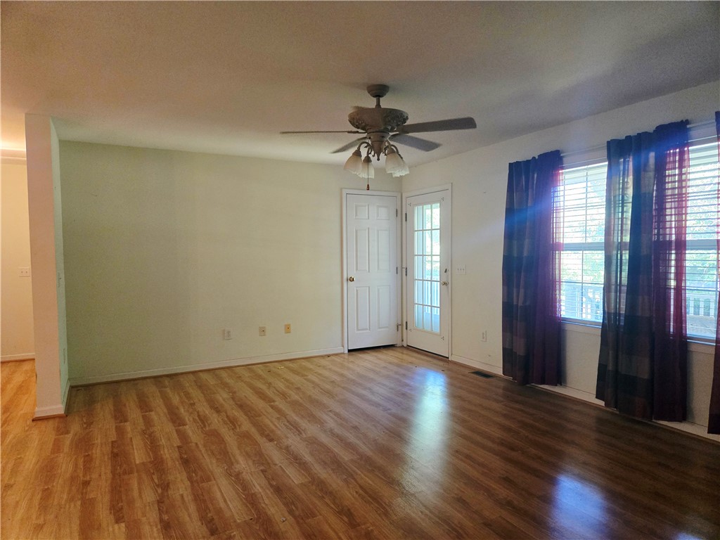 202 Keith Lane Seneca, SC 29678 - Photo 10 of 23 A well-lit living area features warm wood flooring and convenient exterior access.