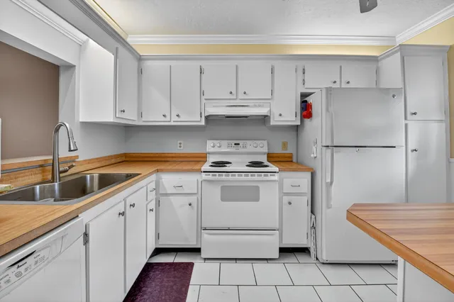 a kitchen with white cabinets and white appliances