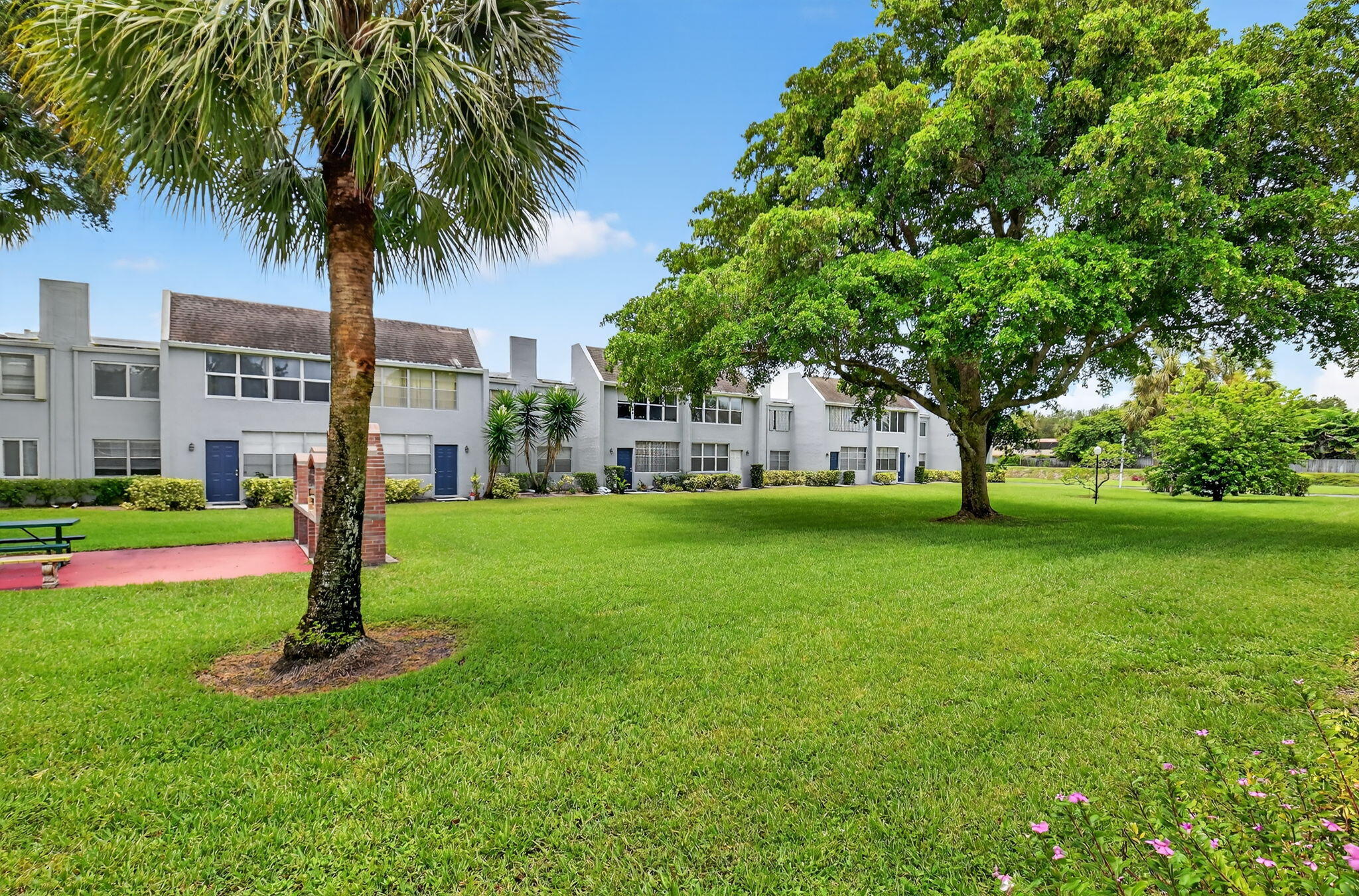 2860 Southwest 22nd Avenue, Unit 4030 Delray Beach, FL 33445 - Photo 22 of 37 a front view of a garden with palm trees