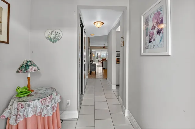 a view of a hallway to a livingroom with furniture and a window