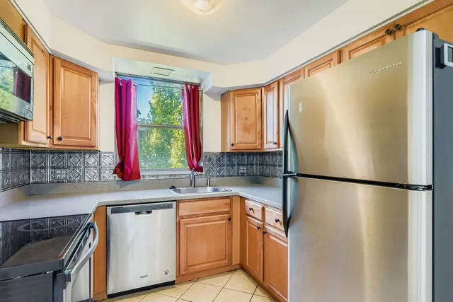 a kitchen with a refrigerator a sink and cabinets