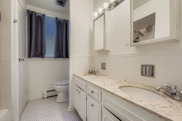 a bathroom with a granite countertop sink toilet and mirror