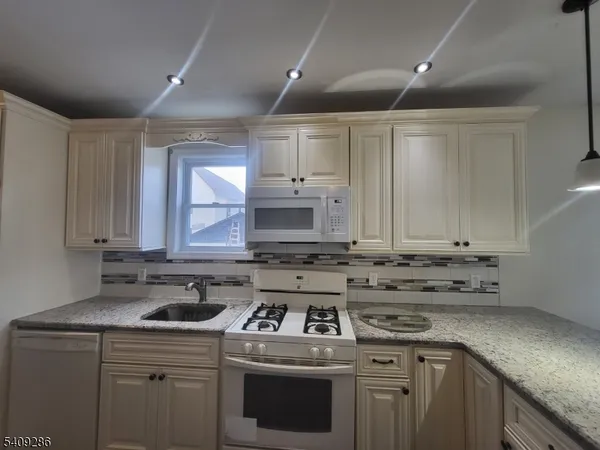 a kitchen with a stove sink and cabinets