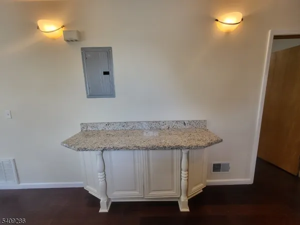 a bathroom with a granite countertop sink and a mirror