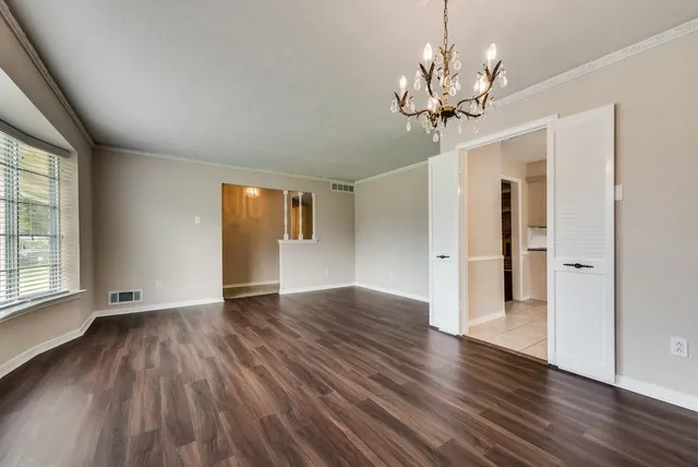 a view of a livingroom with wooden floor and a chandelier