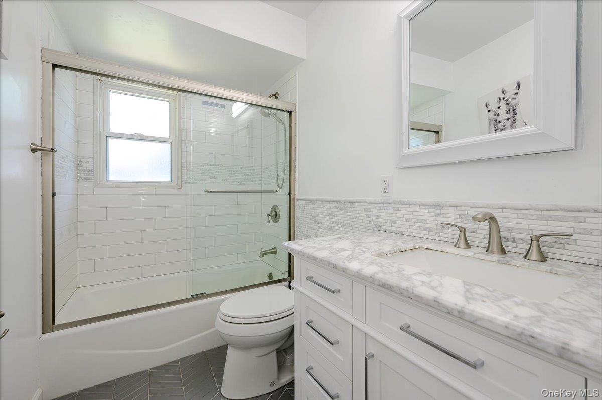 534 Allen Road Woodmere, NY 11598 - Photo 18 of 35 a bathroom with a granite countertop sink a toilet and shower