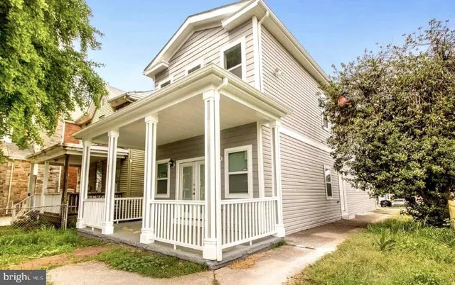 a view of a house with a small yard and wooden fence