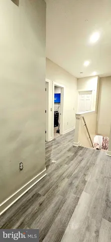 a view of a livingroom with wooden floor and a ceiling fan