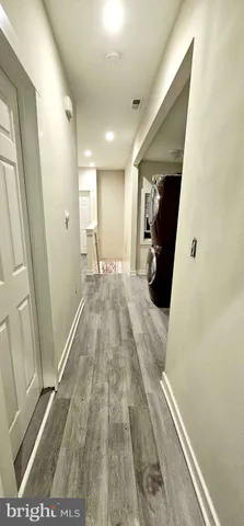 a view of hallway with wooden floor and stairs