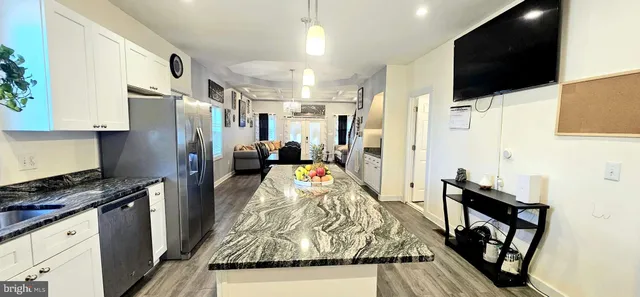 a kitchen with granite countertop a refrigerator stove and microwave