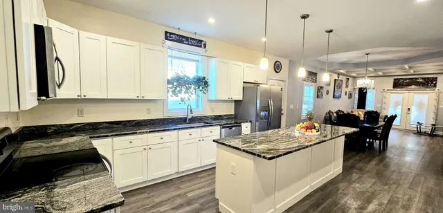 a kitchen with a sink stove and chairs