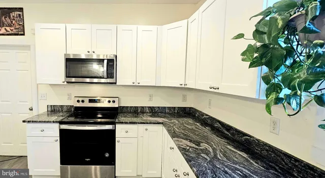 a kitchen with a white cabinets and a stove