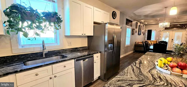 a kitchen with stainless steel appliances granite countertop a refrigerator and a sink