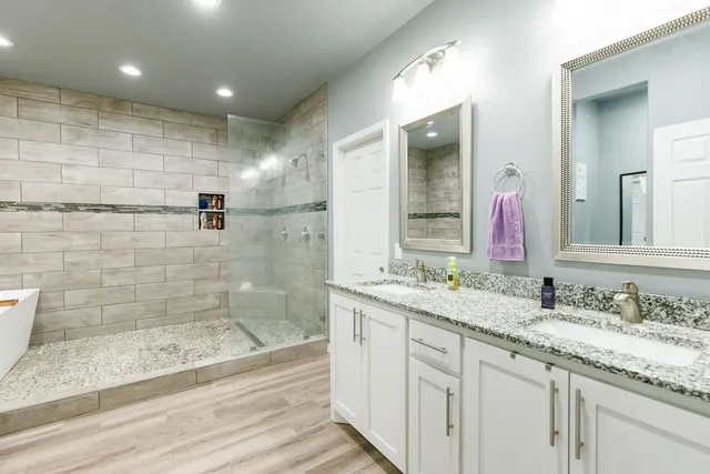 a bathroom with a granite countertop sink mirror and shower