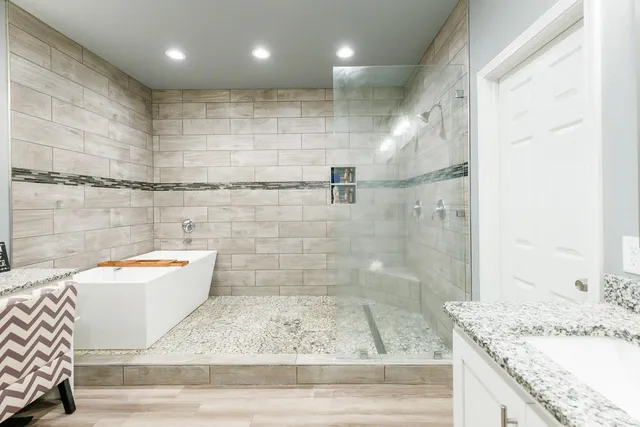 a bathroom with a granite countertop bathtub shower sink and toilet