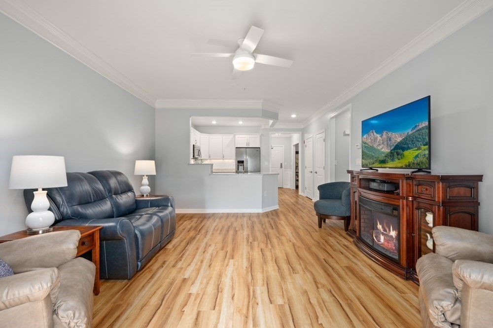 57 Augustus Court, Unit 1010 Reading, MA 01867 - Photo 16 of 32 a living room with furniture and a flat screen tv