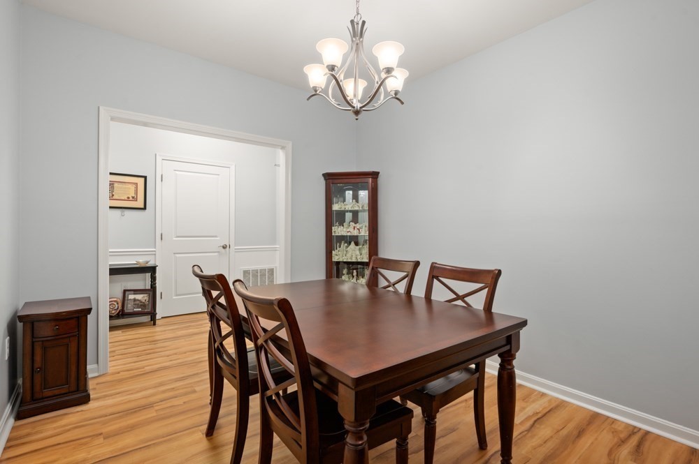 57 Augustus Court, Unit 1010 Reading, MA 01867 - Photo 17 of 32 a view of a dining room with furniture and wooden floor