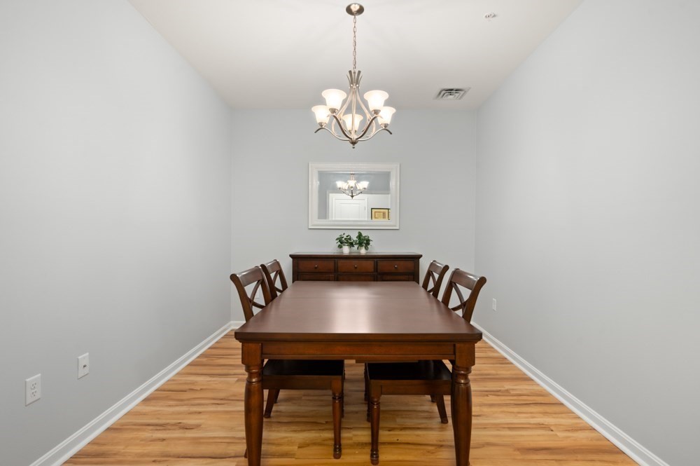 57 Augustus Court, Unit 1010 Reading, MA 01867 - Photo 18 of 32 a view of a dining room with furniture and wooden floor