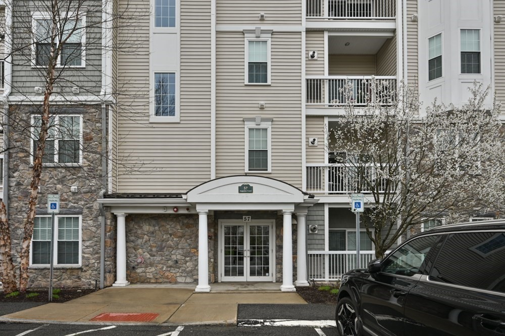 57 Augustus Court, Unit 1010 Reading, MA 01867 - Photo 29 of 32 a front view of a house with parking area