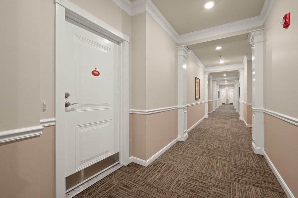 57 Augustus Court, Unit 1010 Reading, MA 01867 - Photo 4 of 32 a view of a hallway with closet and wooden floor
