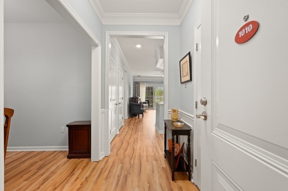 57 Augustus Court, Unit 1010 Reading, MA 01867 - Photo 5 of 32 a view of a hallway with wooden floor and staircase