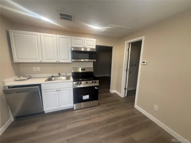 a kitchen with stainless steel appliances granite countertop a stove a sink and a refrigerator