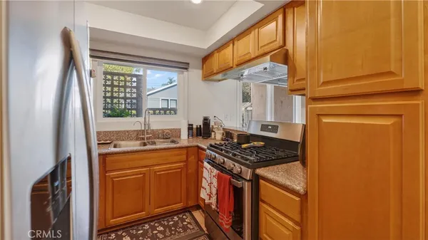 a kitchen with stainless steel appliances granite countertop a stove a sink and a refrigerator