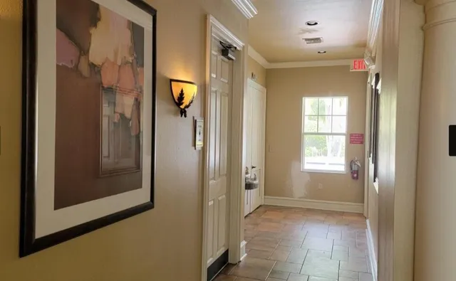 a view of an empty room with a bathroom and a mirror