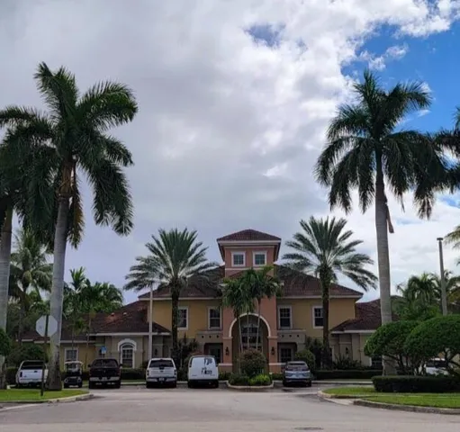 a front view of multiple houses with palm trees