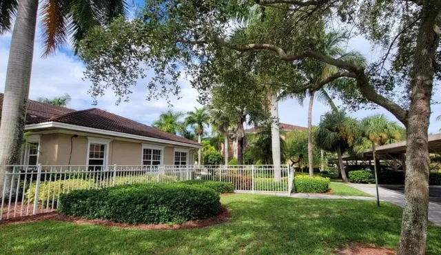 a view of house with a big yard and potted plants and large trees