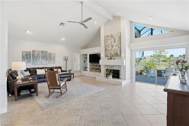 a living room with furniture a fireplace and a large window