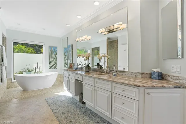 a white bath tub sitting in a bathroom next to a window