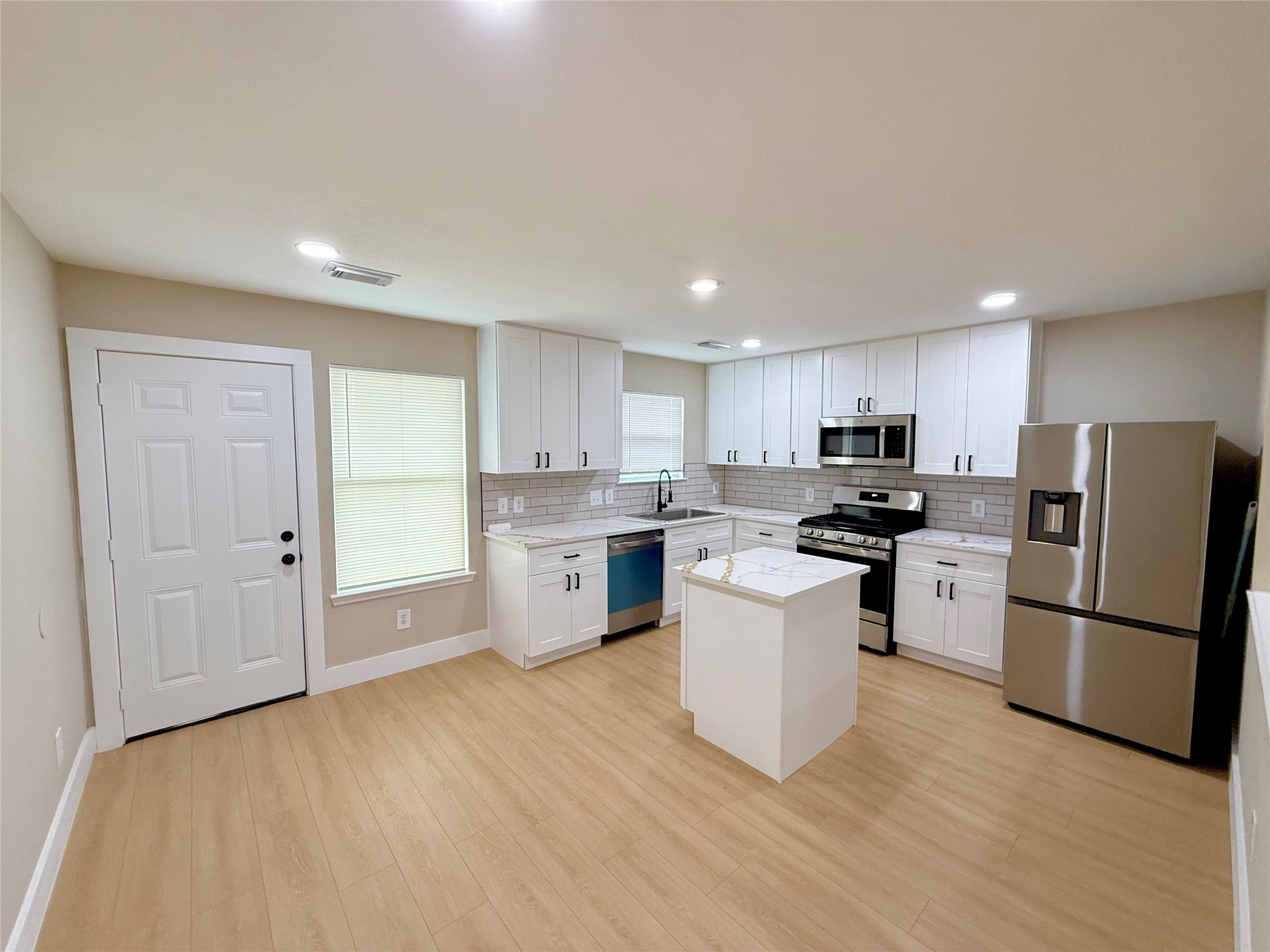 3819 Banks Ridge Lane Katy, TX 77449 - Photo 5 of 13 a kitchen with white cabinets and stainless steel appliances