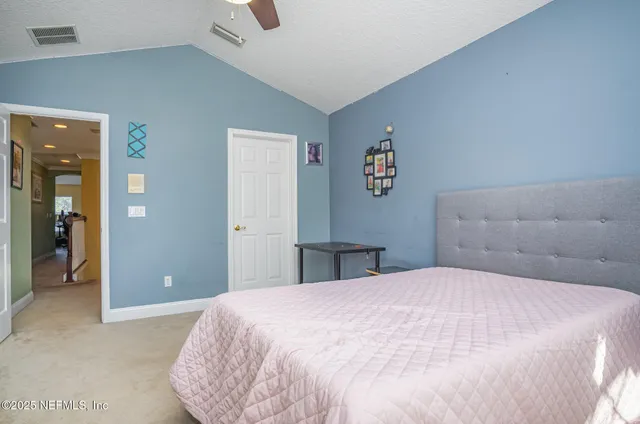 a bedroom with a large bed and chandelier