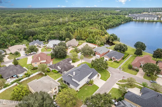 an aerial view of residential houses with outdoor space and river