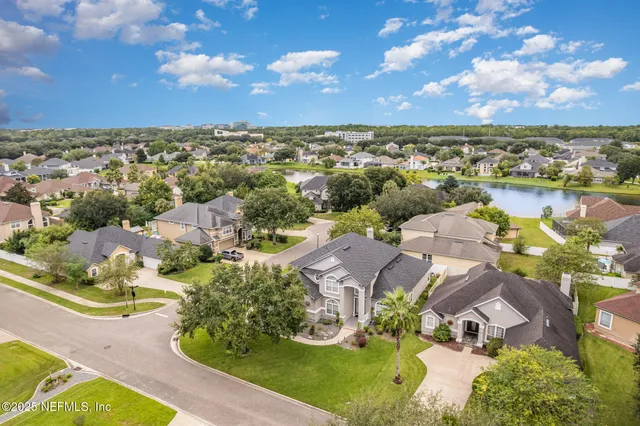 an aerial view of residential house with outdoor space and lake view in back