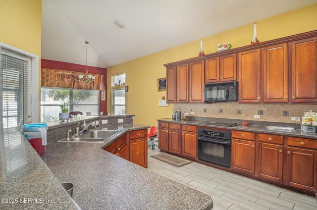 a large kitchen with stainless steel appliances granite countertop a sink stove and cabinets