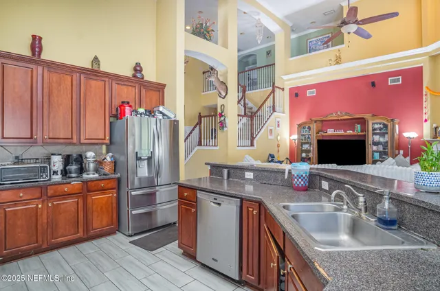 a kitchen with stainless steel appliances granite countertop a sink and dishwasher refrigerator stove