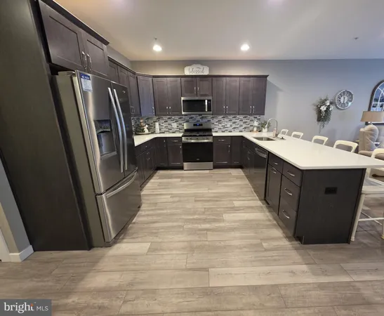 a kitchen with stainless steel appliances granite countertop a refrigerator and a sink