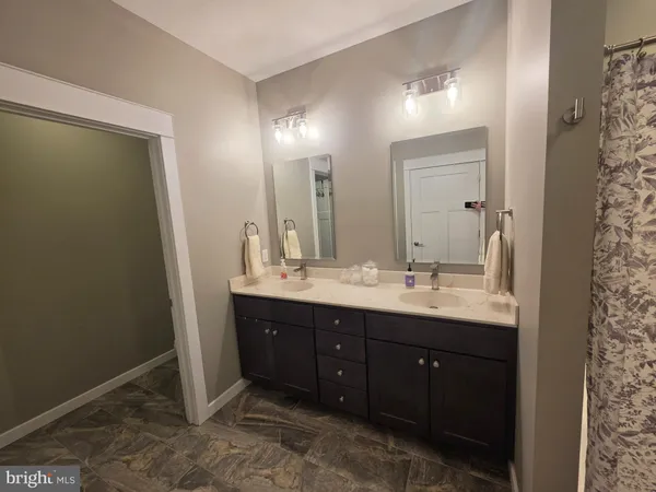 a bathroom with a double vanity sink and a mirror