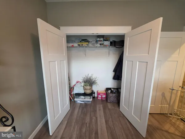 a view of hallway with furniture and wooden floor